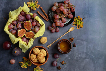 autumn harvest frame background. Still life of autumn food with seasonal fruits, grapes and figs, honey on a dark gray table. Thanksgiving Day