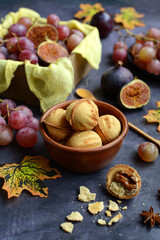 Close-up of delicious cookies with condensed milk, figs, grapes, honey, spices on a dark gray table. Vertical photography
