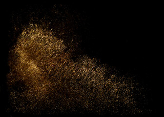 Fototapeta na wymiar Golden sequins glisten with dust isolated on a black background. Horizontal abstract background with sparkling dust, space for text