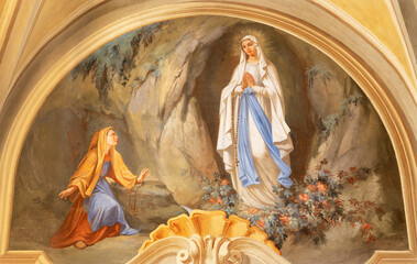 COURMAYEUR, ITALY - JULY 12, 2022: The fresco of apparition of Virgin Mary in Lourdes in church Chiesa di San Pantaleone by Nino Pirlato (1957).