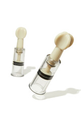 Cropped close-up shot of a pair of vacuum twist suckers for stimulation nipples. Vacuum nipple suckers for sexual play are isolated on a white background. Front view.