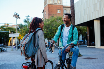 Cheerful couple with bicycles outside.