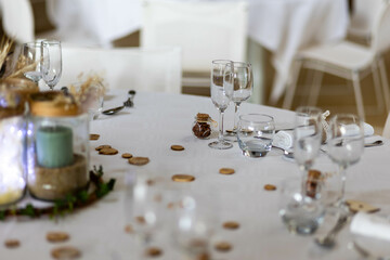 Table de mariage avec des verres, des décorations en bois, des lumières et des fleurs