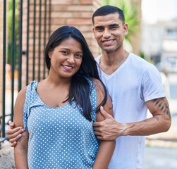 Man and woman couple smiling confident hugging each other at street