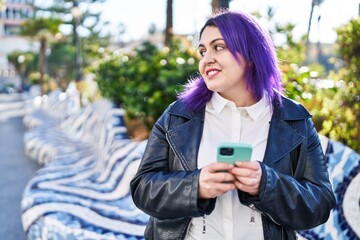 Young beautiful plus size woman smiling confident using smartphone at park