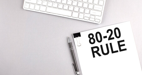 80-20 RULE text on paper with keyboard on grey background