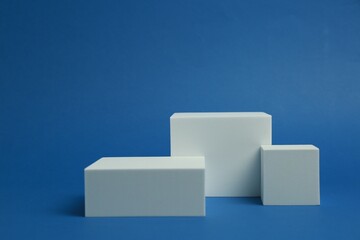 Product photography props. Podiums of different geometric shapes on blue background