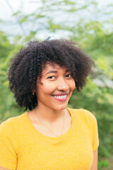 Portrait Latina woman looking at the camera while posing on a natural green background.