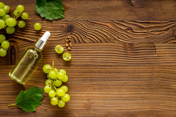 Bottle of grape seed oil with green grapes. Eco cosmetic product