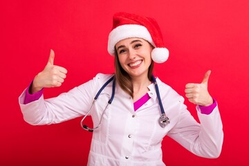 A smiling nurse in a Santa Claus hat shows the class and looks at the camera on a red background