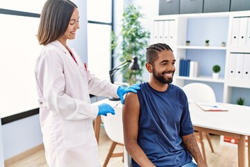 Fototapeta premium Man and woman wearing doctor uniform vaccinating at clinic