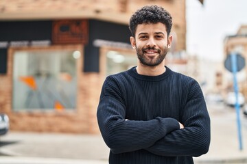 Young arab man smiling confident standing with arms crossed gesture at street