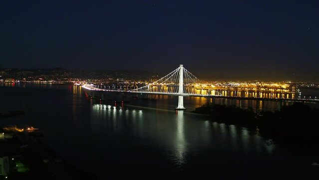 Aerial Backward Shot Of Illuminated Famous Suspension Bridge Over Sea Against Clear Sky At Night - San Francisco, California
