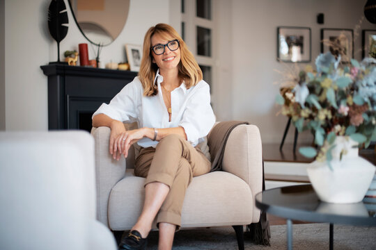 Beautiful Woman Wearing Casual Clothes While Sitting In An Armchair At Home