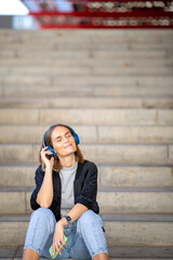 happy woman enjoying music with headphones and cellphone