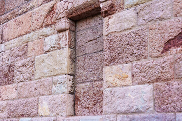 Bricked up window of an old ancient building with stone wall