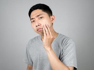 Close up asian man checking acne on his face feels worried isolated