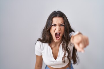 Fototapeta premium Young teenager girl standing over white background pointing displeased and frustrated to the camera, angry and furious with you
