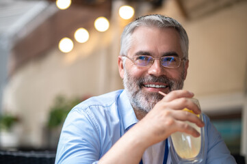 Smiling man with a glass in hands looking happy