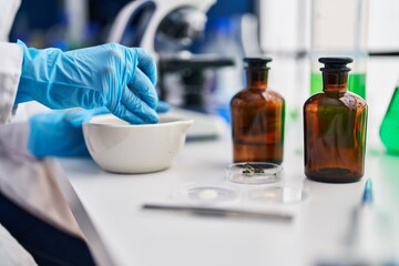 African american woman wearing scientist uniform working laboratory