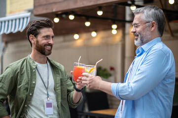 Two friends having a cocktail and looking excited