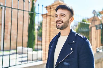 Naklejka premium Young hispanic man smiling confident looking to the side at street