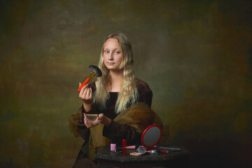 Beaty. Beautiful young girl as Mona Lisa picture using makeup brush over dark vintage background....