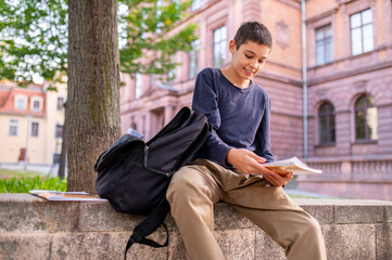 Pleased adolescent reading a title on the book cover