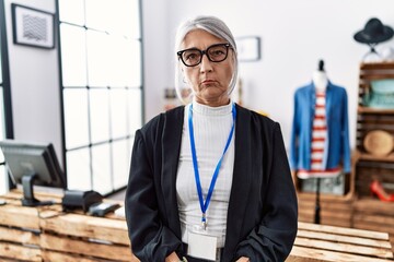 Middle age grey-haired woman working as manager at retail boutique depressed and worry for...