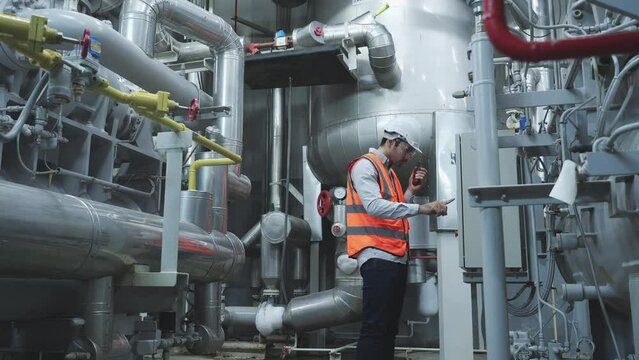 Industrial engineer working and communication for inspect factory and machine standards. Engineer male working at factory. Concept of industry, factory, environment and professional people.