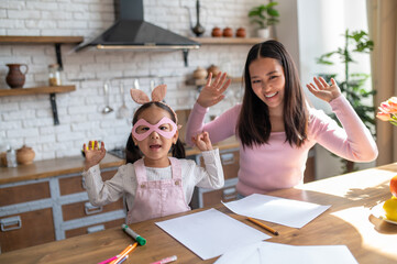 Girl and mom posing for the camera in the kitchen