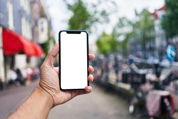 Man holding smartphone showing white blank screen at amsterdam