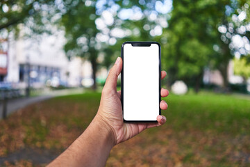 Man holding smartphone showing white blank screen at park
