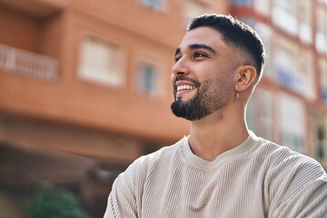 Young arab man smiling confident standing at street