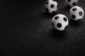 Several classic soccer balls on a dark background.