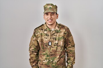 Young arab man wearing camouflage army uniform winking looking at the camera with sexy expression, cheerful and happy face.