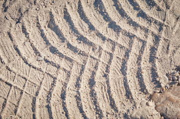 Tire tracks in the sand on a sunny day