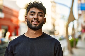 Young arab man smiling confident at street