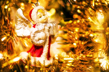 Cute toy angel hanging on decorating a Christmas tree