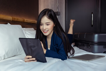 Business Technology Internet Hotel Vacation Concept Happy young businesswoman using tablet computer...