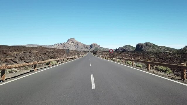 Drone footage flying over empty road across lava rocks in mountainous area. Mt. Teide. Tenerife, Spain. Teide National Park.
