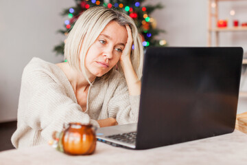Frustrated woman in front of a laptop during the Christmas holidays
