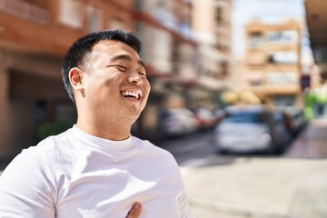 Fototapeta premium Young chinese man smiling confident standing at street