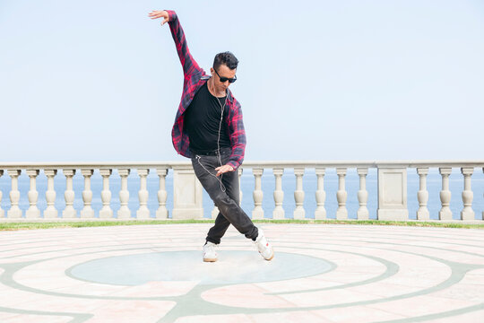Man wearing headphones and dancing on promenade