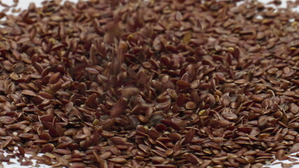 Heap flax seeds falling on creamy surface dairy dessert close up. Healthy food.