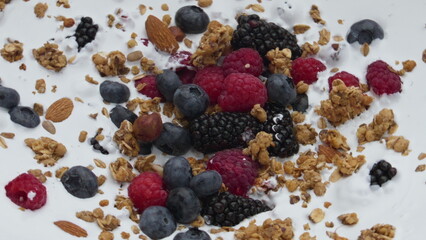 Healthy berry crunchy breakfast with natural yogurt in super slow motion closeup