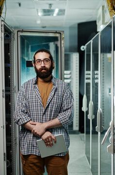Computer programmer with beard holding tablet PC in server room