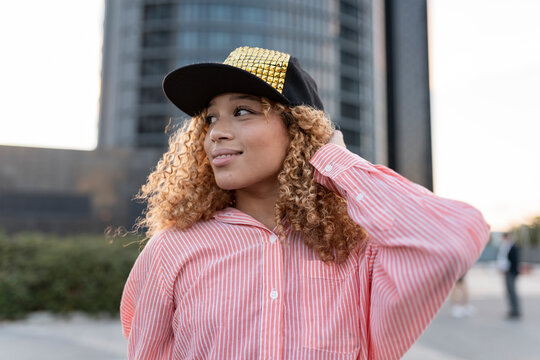 Smiling woman in striped button down shirt wearing cap