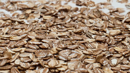 Raw oat flakes dropped into natural yogurt for healthy breakfast close up.