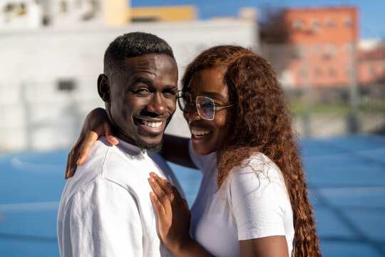 Happy woman embracing boyfriend on sunny day